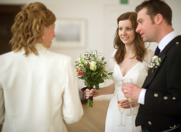 Bride And Groom Talking To A Woman At Their Wedding Celebration